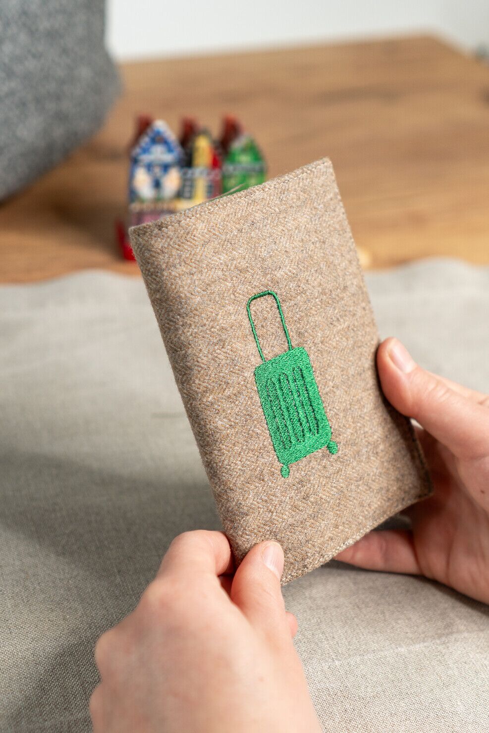 reisepasshuelle-upcycling-taupe-gruener-koffer-handgemacht-naturmaterial.jpg Handgefertigte Reisepasshülle aus Stoffresten mit grünem Koffer als Detail
