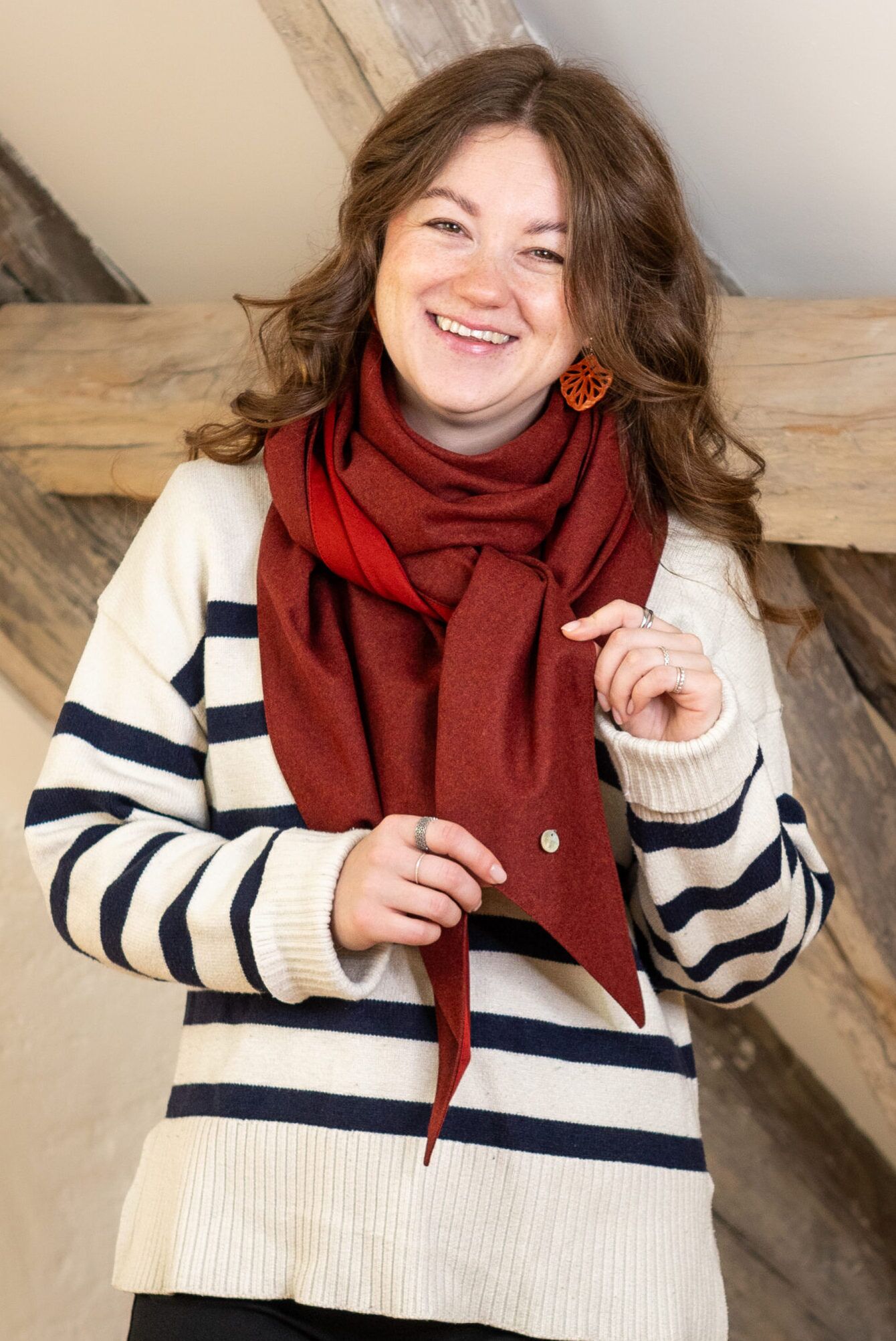 kiara-lodentuch-rostrot-alltag.jpg Rostrotes Lodentuch KIARA als Schal zu einem schlichten Alltags-Outfit mit gestreiftem Pullover getragen.